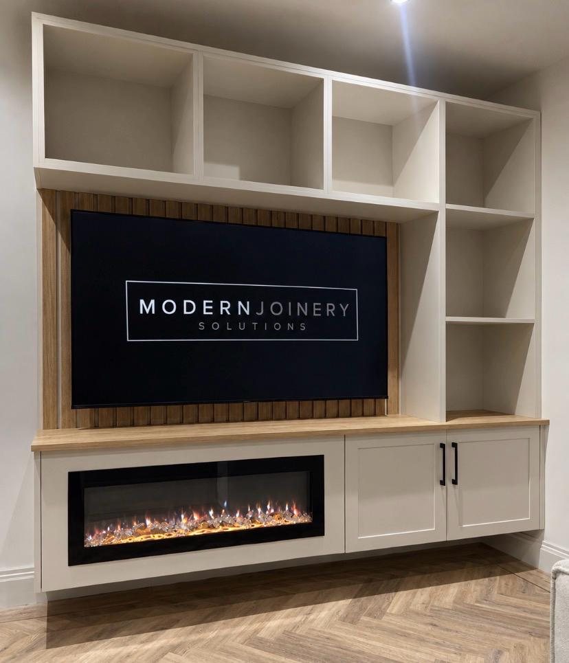 Fitted media wall with open shelving, slatted oak panel behind the TV, an electric fire and shaker cupboards