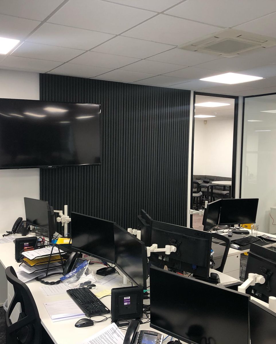 Dark slatted acoustic panelling on an office wall