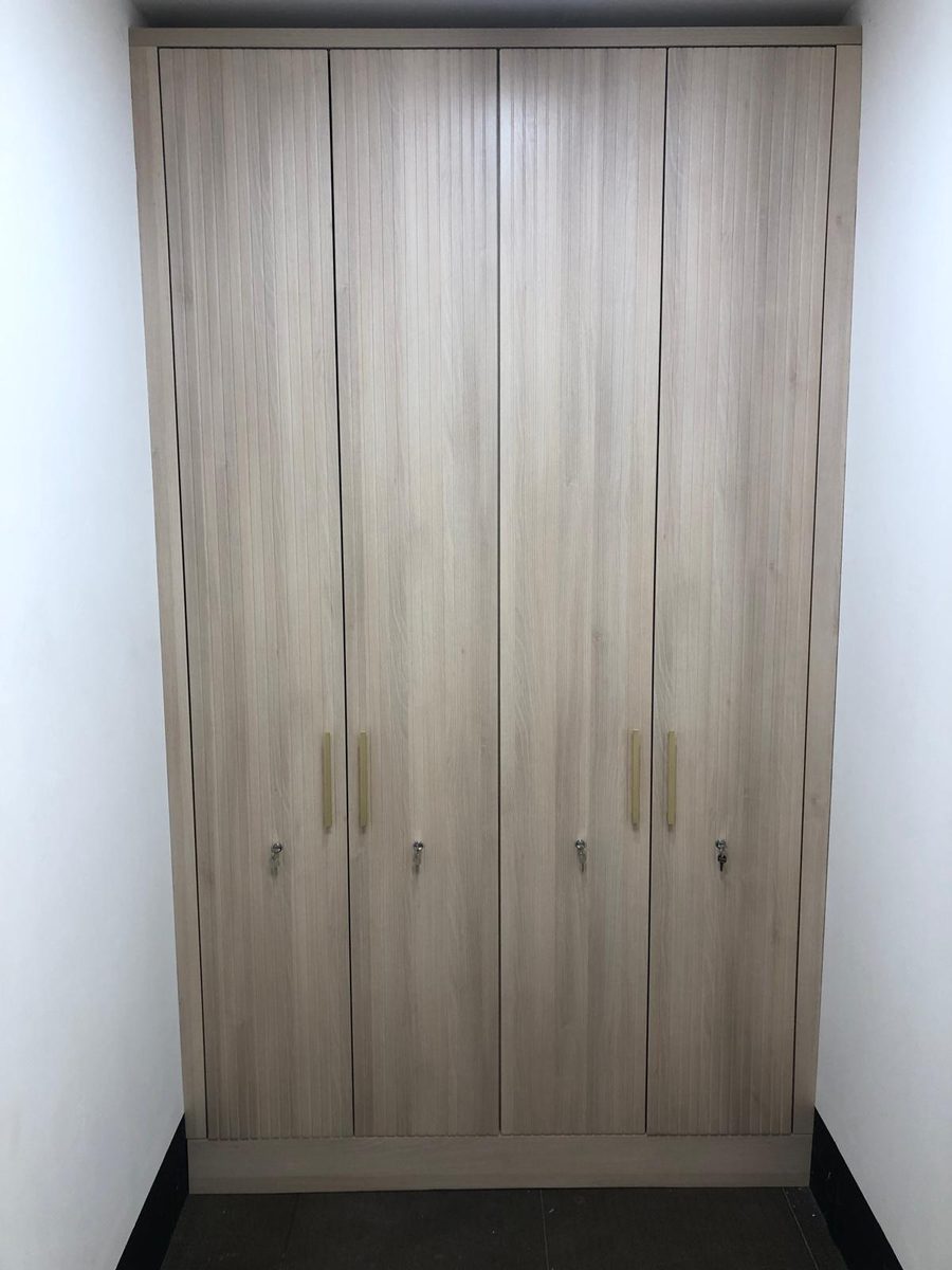 Oak-effect fitted wardrobes with fluted brass handles